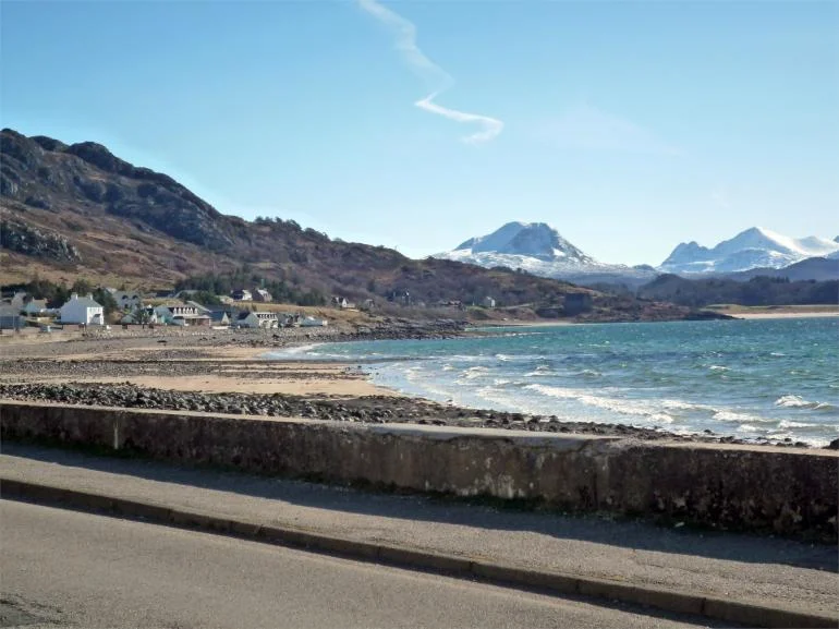 Windy day at Gairloch beach in the Highlands with small waves rolling in.