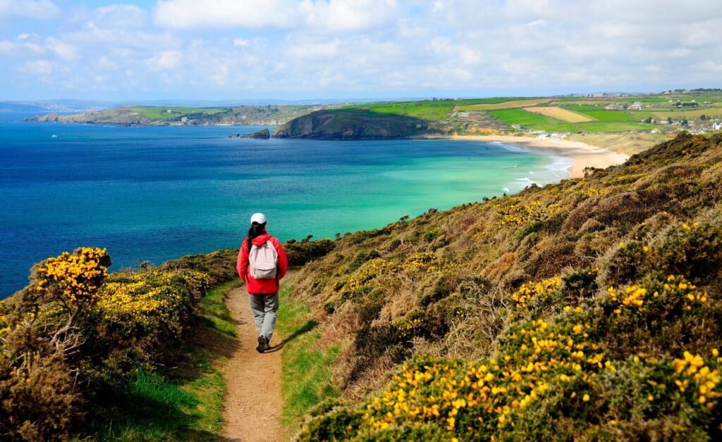 Girl walking on the south west coast path in Cornwall