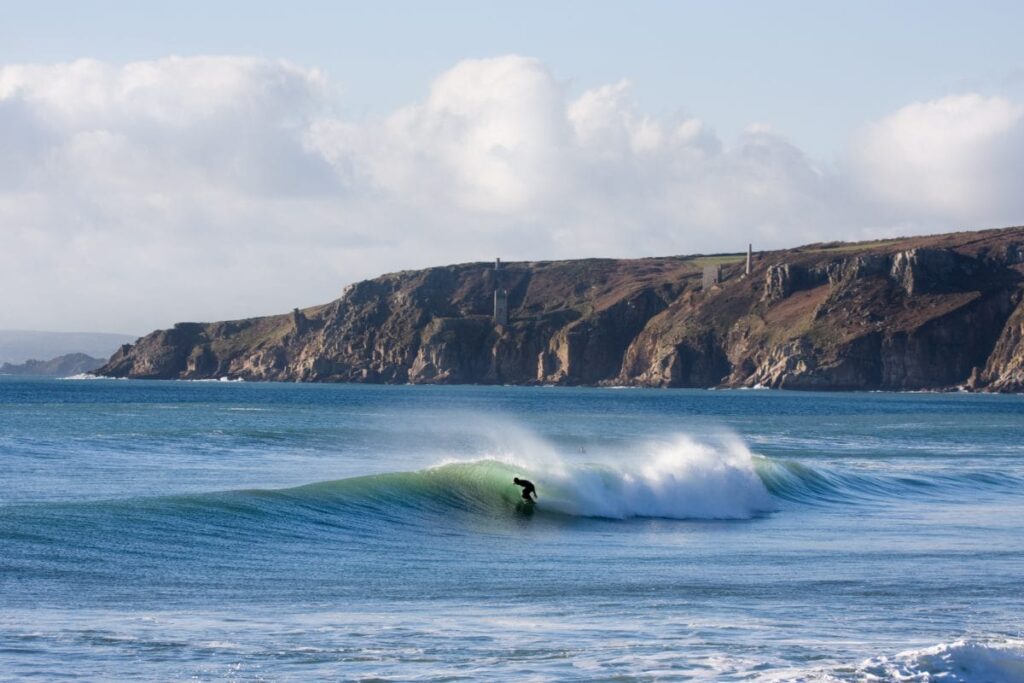 Lone surfer in Newquay, Cornwall catching a medium sized wave