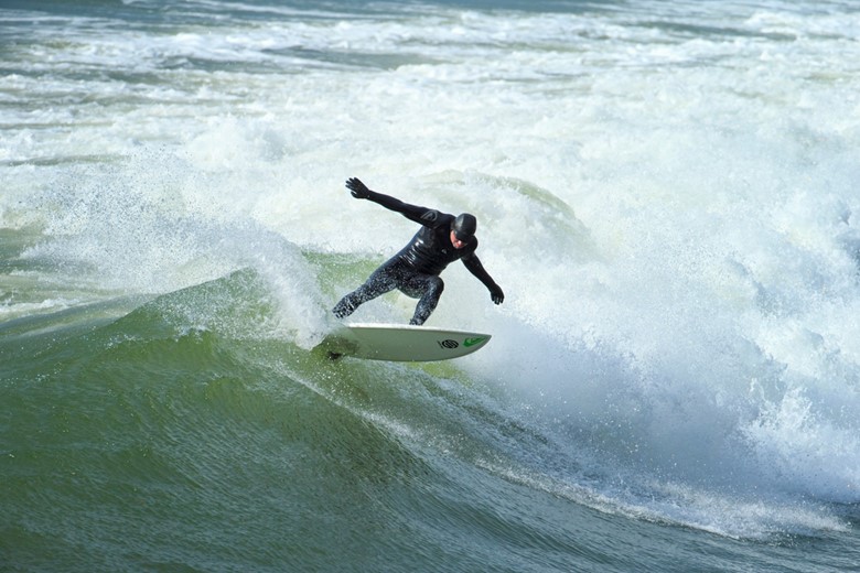 Surfer enjoying a wave on Aberporth Beach