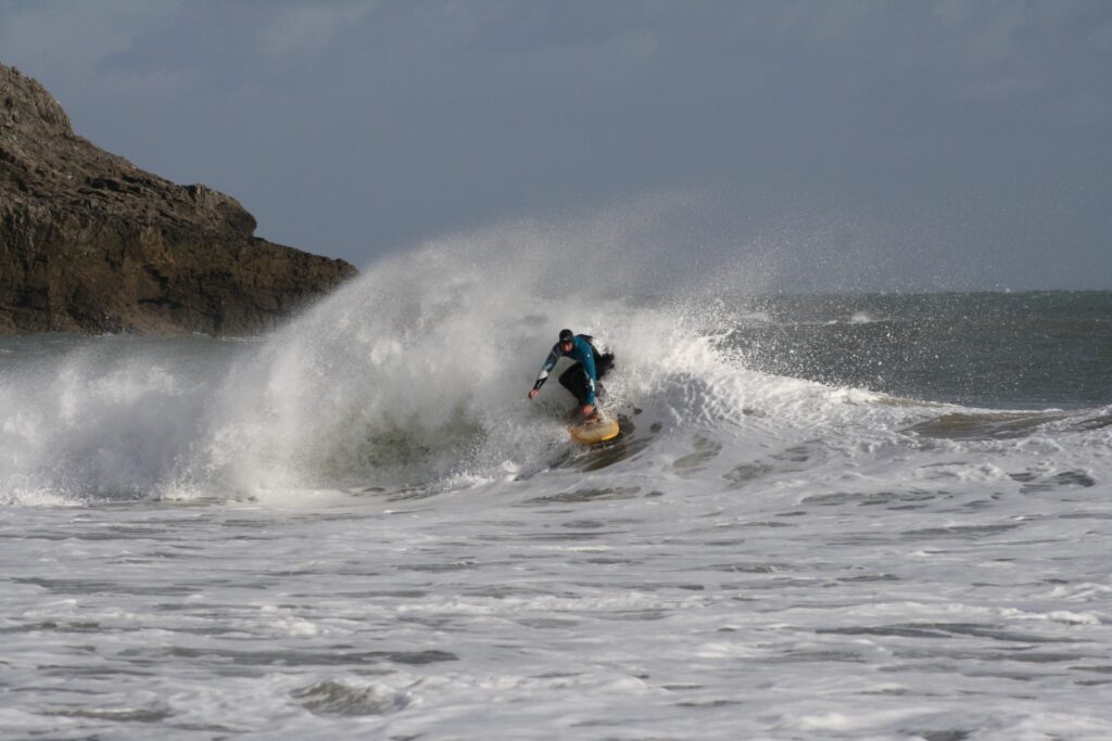 Surfer on a wave at Newgale Beach in Pembrokeshire