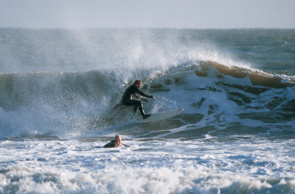 Two surfers at Tenby South Beach catching a small break