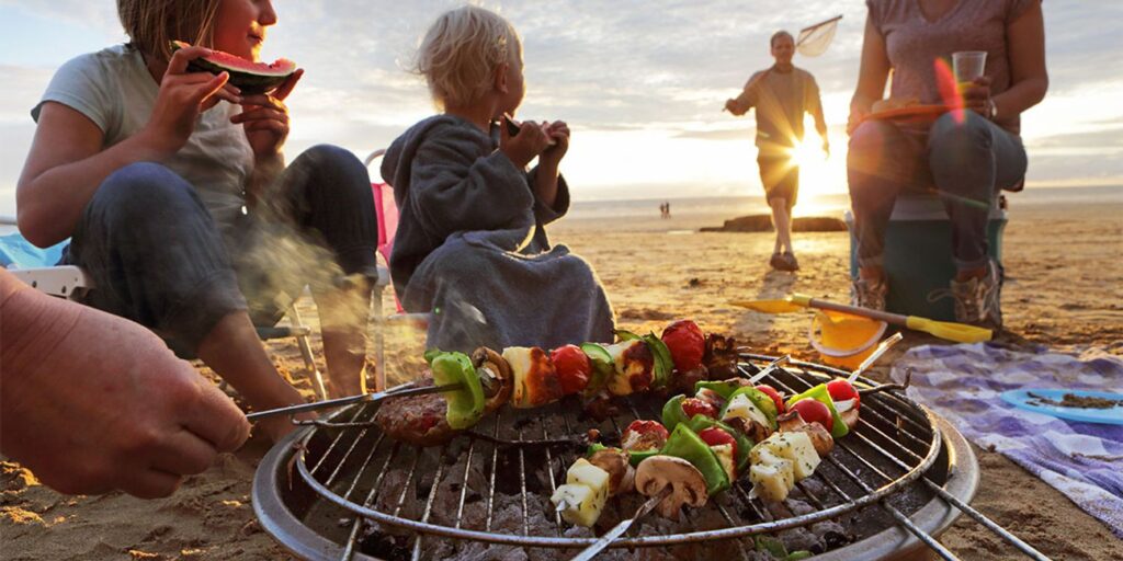 BBQ on the beach at dusk.