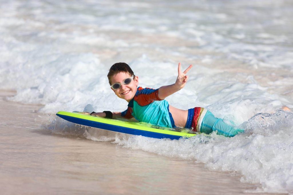 Young boy bodyboarding in the sea