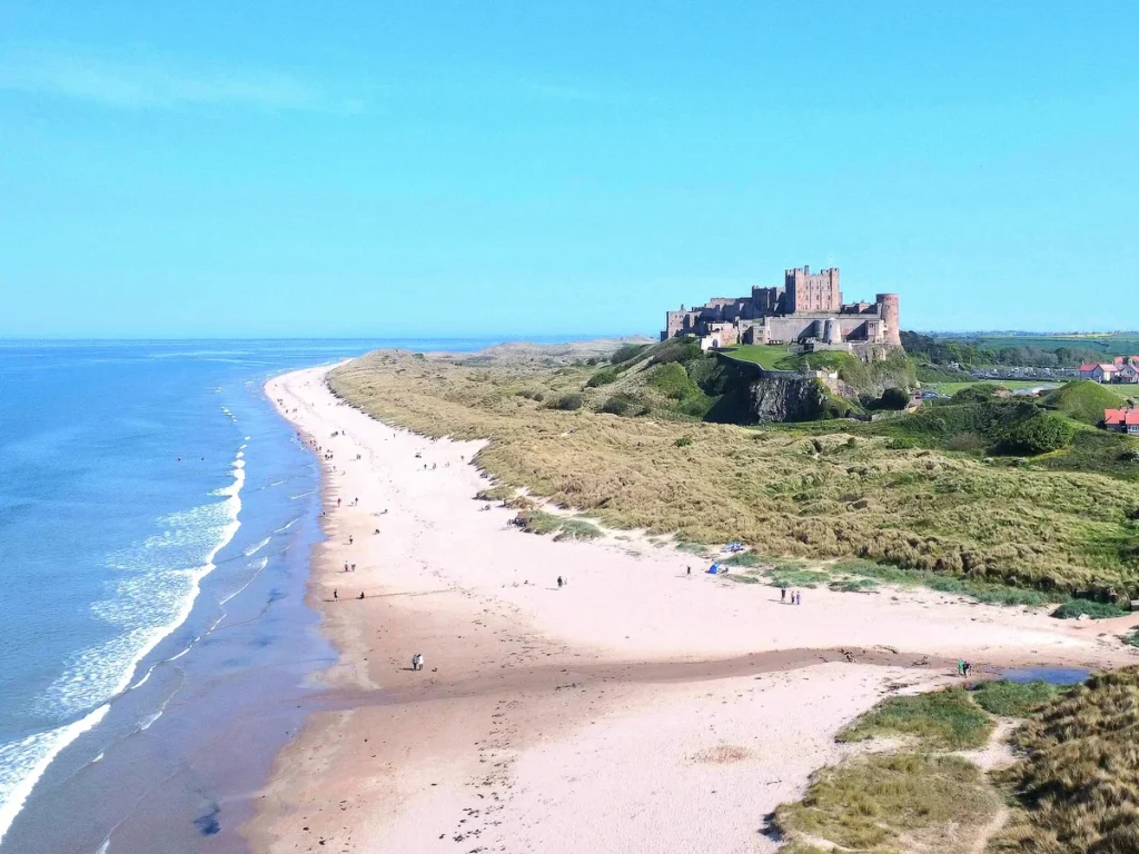 Bamburgh Castle rising up next to the beach
