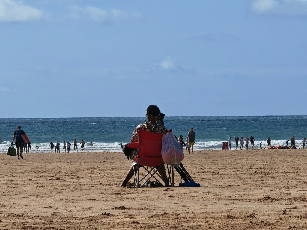 Lady sitting on a deckchair staring out to sea at Woolacombe beach in Devon