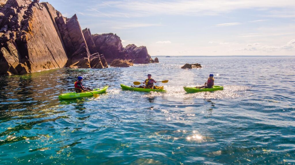 Kayakers enjoying a paddle in calm waters near St Davids